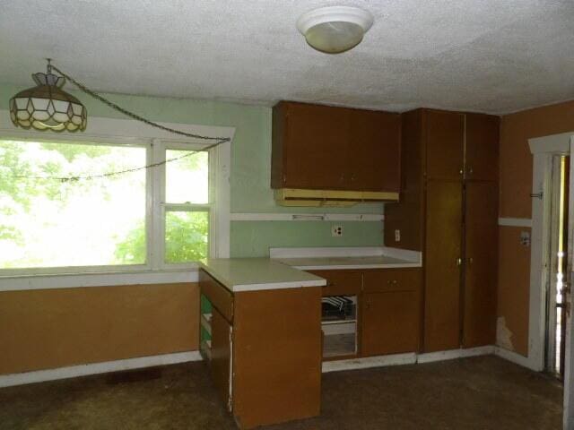 209 E High St, Union City, MI 49094 - kitchen featuring brown cabinets, light countertops, and a textured ceiling