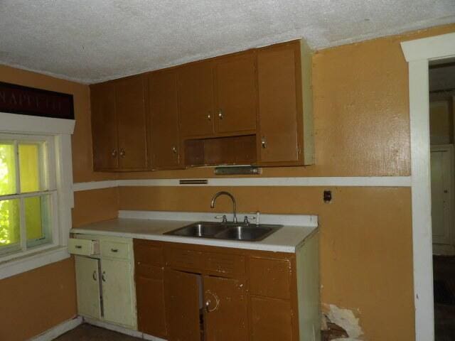 209 E High St, Union City, MI 49094 - kitchen featuring light countertops, a textured ceiling, and brown cabinets