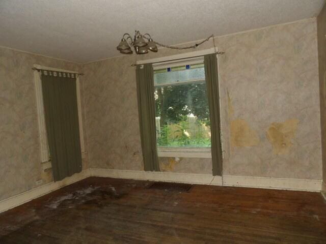 209 E High St, Union City, MI 49094 - unfurnished room featuring wood finished floors, a chandelier, and a textured ceiling