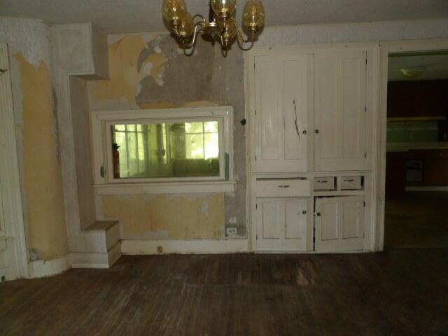 209 E High St, Union City, MI 49094 - unfurnished dining area featuring a chandelier and dark wood-style floors