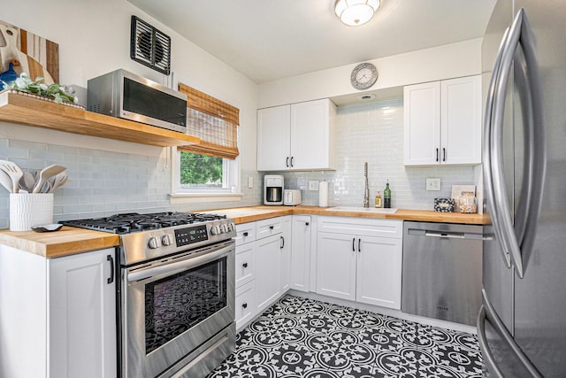 1805 Cambridge Dr, Kalamazoo, MI 49001 - kitchen featuring stainless steel appliances, butcher block counters, tasteful backsplash, and white cabinetry