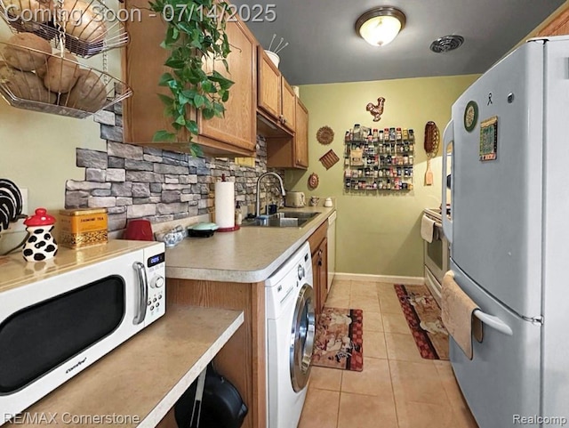 7382 Central St Unit 4, Westland, MI 48185 - kitchen featuring freestanding refrigerator, washer / dryer, backsplash, light countertops, and brown cabinetry