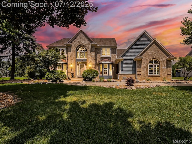 12495 Howland Park Dr, Plymouth, MI 48170 - traditional-style home featuring a front lawn and brick siding