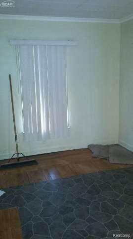 1702 Nebraska Ave, Flint, MI 48506 - spare room featuring stone flooring and ornamental molding