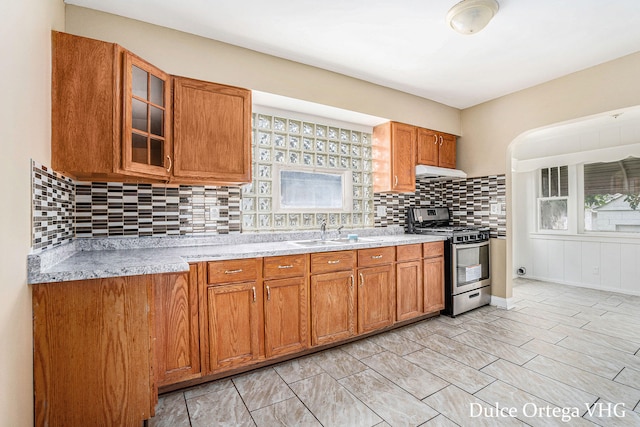 2025 Palace Ave SW, Grand Rapids, MI 49507 - kitchen featuring gas range, under cabinet range hood, light countertops, and brown cabinets