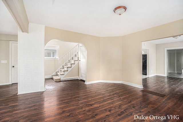 2025 Palace Ave SW, Grand Rapids, MI 49507 - spare room with arched walkways, wood finished floors, and stairs