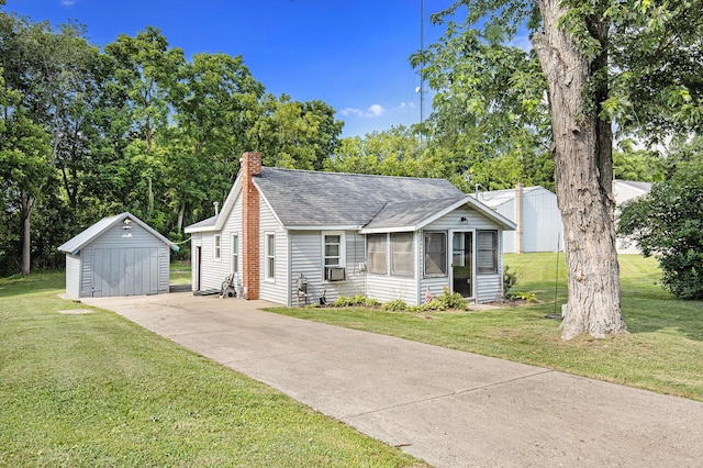 95 W N St, Ionia, MI 48846 - view of front of home with a storage unit, roof with shingles, a chimney, a sunroom, and a detached garage