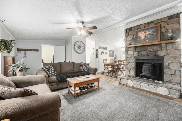 797 Beaver Rd, Bitely, MI 49309 - living room featuring a textured ceiling, crown molding, wood finished floors, a ceiling fan, and a stone fireplace
