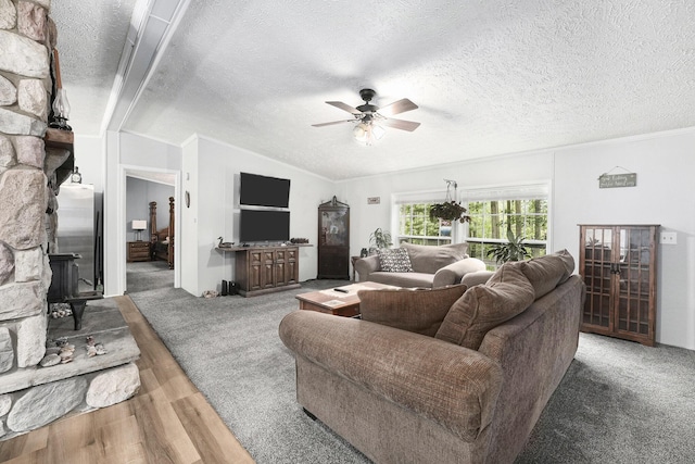 797 Beaver Rd, Bitely, MI 49309 - living area with a ceiling fan, lofted ceiling, a wood stove, wood finished floors, and a textured ceiling