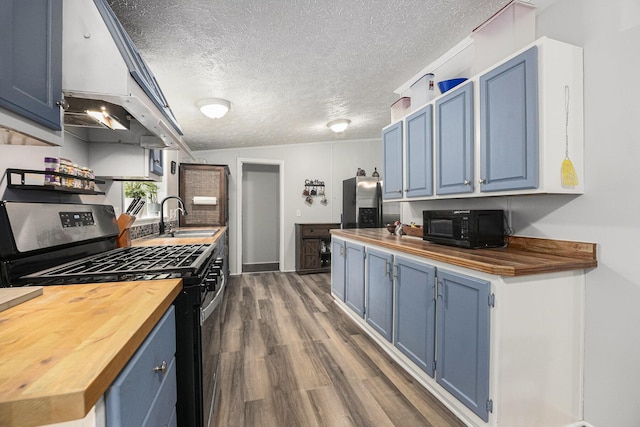 797 Beaver Rd, Bitely, MI 49309 - kitchen featuring wood counters, appliances with stainless steel finishes, blue cabinetry, dark wood finished floors, and a textured ceiling