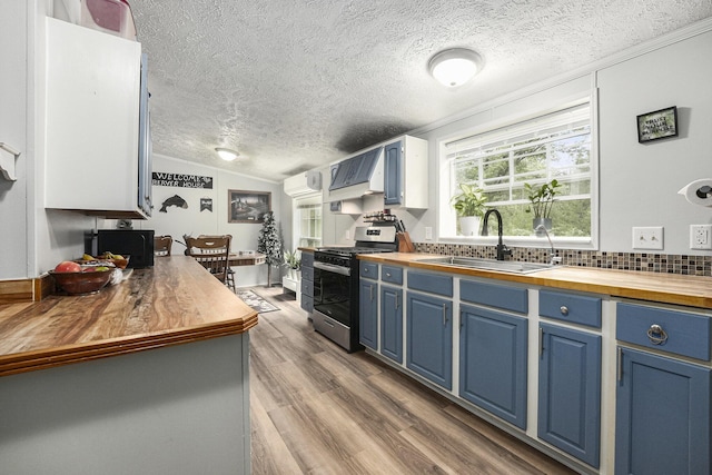 797 Beaver Rd, Bitely, MI 49309 - kitchen with stainless steel range with gas stovetop, butcher block countertops, blue cabinets, a textured ceiling, and lofted ceiling