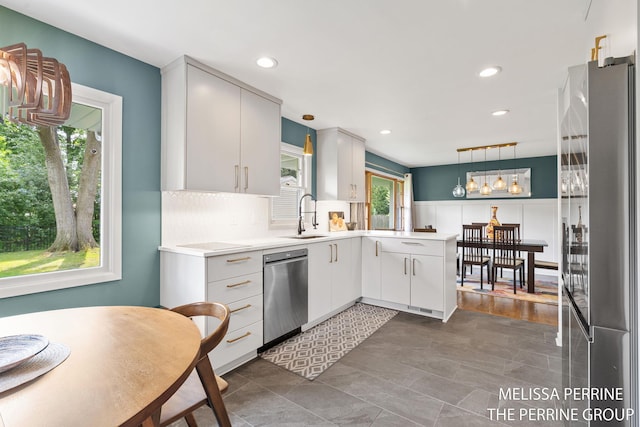 116 Loch Lomond Ave NE, Grand Rapids, MI 49546 - kitchen featuring stainless steel appliances, a peninsula, light countertops, a wainscoted wall, and recessed lighting