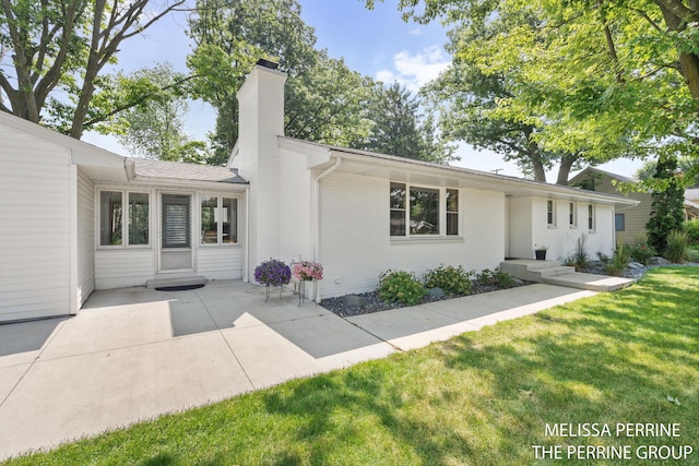 116 Loch Lomond Ave NE, Grand Rapids, MI 49546 - view of front facade featuring a chimney, a front yard, a patio area, and brick siding