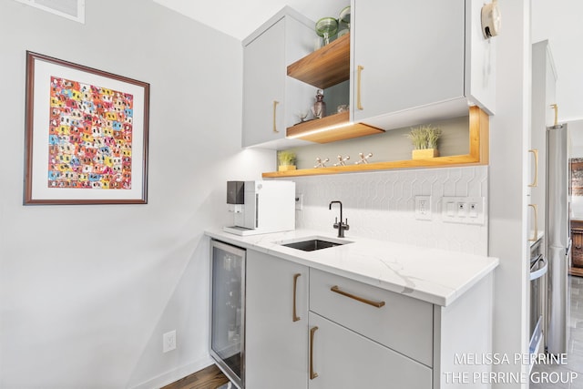 116 Loch Lomond Ave NE, Grand Rapids, MI 49546 - kitchen with open shelves, backsplash, light stone countertops, and wine cooler