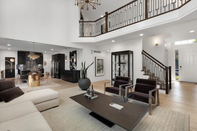 3909 Sandpiper Dr, Troy, MI 48083 - living area featuring light wood-style flooring, stairway, a towering ceiling, a chandelier, and recessed lighting