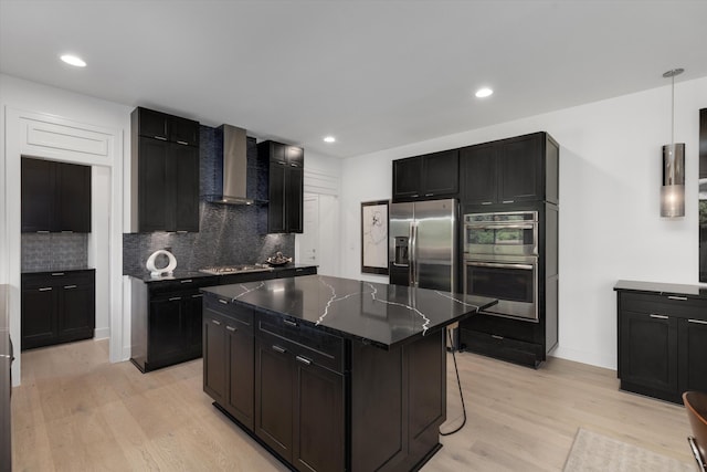 3909 Sandpiper Dr, Troy, MI 48083 - kitchen featuring wall chimney range hood, stainless steel appliances, a kitchen island, light wood-type flooring, and tasteful backsplash