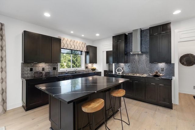 3909 Sandpiper Dr, Troy, MI 48083 - kitchen with wall chimney exhaust hood, a center island, light wood finished floors, a breakfast bar area, and decorative backsplash