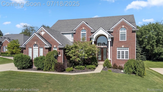 25506 Stanley Ln, South Lyon, MI 48178 - traditional-style home with brick siding, a front yard, and roof with shingles