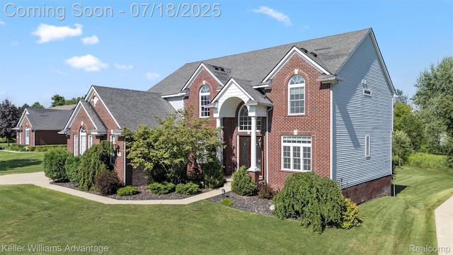 25506 Stanley Ln, South Lyon, MI 48178 - traditional home featuring a front lawn, brick siding, and roof with shingles