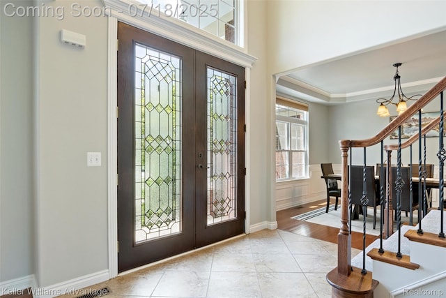 25506 Stanley Ln, South Lyon, MI 48178 - foyer entrance featuring french doors, stairway, a chandelier, and ornamental molding