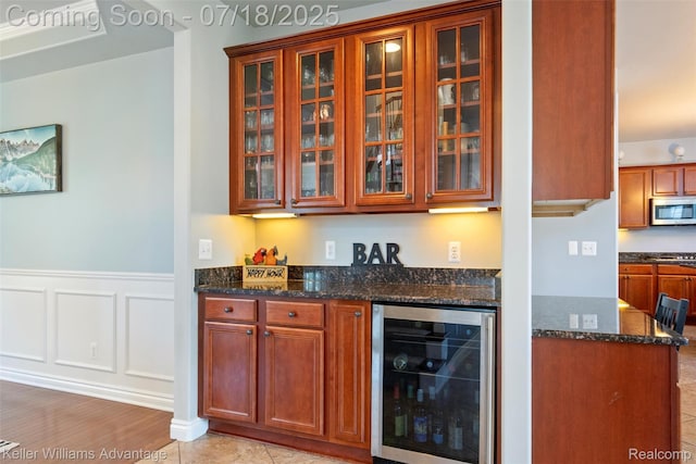 25506 Stanley Ln, South Lyon, MI 48178 - indoor bar with beverage cooler, stainless steel microwave, a wainscoted wall, and a decorative wall