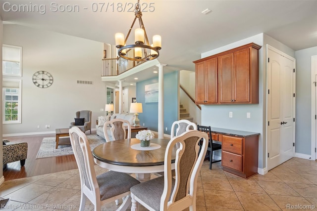 25506 Stanley Ln, South Lyon, MI 48178 - dining room featuring stairway, a chandelier, light tile patterned flooring, and a towering ceiling