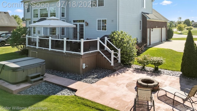 25506 Stanley Ln, South Lyon, MI 48178 - back of property with a hot tub, a fire pit, a deck, concrete driveway, and a patio