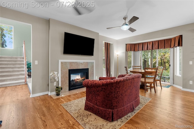 9589 Wellington Ct, Clarkston, MI 48348 - living room with ceiling fan, stairway, light wood-style floors, and a fireplace