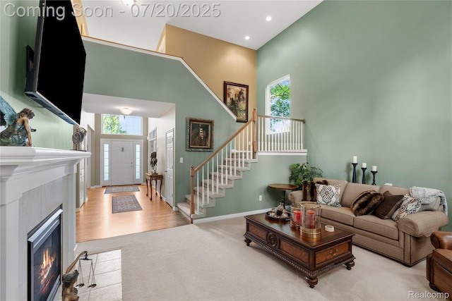 9589 Wellington Ct, Clarkston, MI 48348 - carpeted living room featuring plenty of natural light, a high ceiling, stairway, recessed lighting, and a fireplace with flush hearth