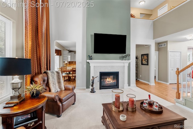 9589 Wellington Ct, Clarkston, MI 48348 - living room featuring a towering ceiling, stairs, and a tile fireplace