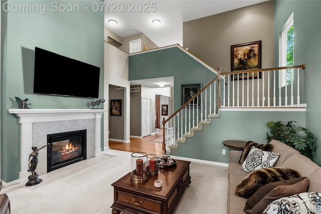 9589 Wellington Ct, Clarkston, MI 48348 - carpeted living area with a fireplace, stairway, and a towering ceiling