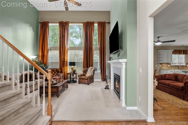 9589 Wellington Ct, Clarkston, MI 48348 - living area with ceiling fan, stairway, and a fireplace with flush hearth