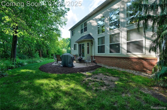 9589 Wellington Ct, Clarkston, MI 48348 - back of property featuring brick siding, a patio, and a lawn