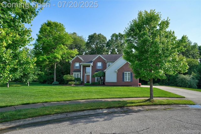 9589 Wellington Ct, Clarkston, MI 48348 - view of front of house with a front yard, brick siding, and driveway