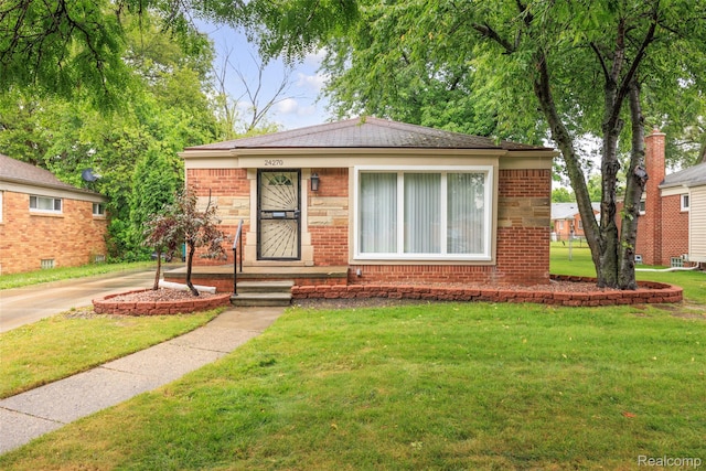 24270 Scotia Rd, Oak Park, MI 48237 - bungalow-style home with brick siding, a front yard, and a shingled roof