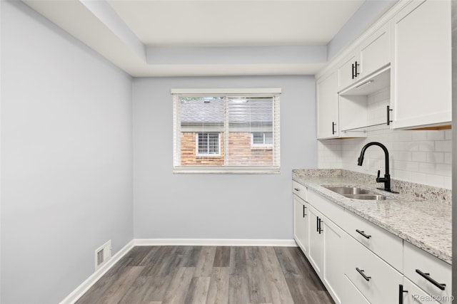 24270 Scotia Rd, Oak Park, MI 48237 - kitchen with tasteful backsplash, dark wood-style flooring, light stone countertops, and white cabinets