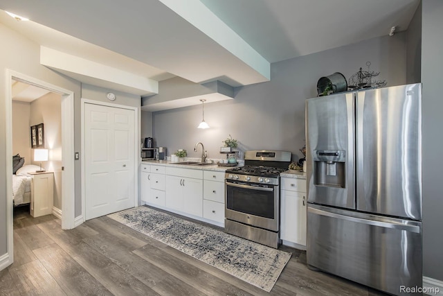 4500 Red Oak Blvd, Waterford, MI 48329 - kitchen featuring stainless steel appliances, light countertops, dark wood-style flooring, white cabinets, and decorative light fixtures