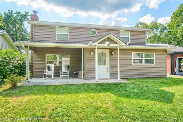 166 Indian Trl, Columbiaville, MI 48421 - traditional-style house featuring a chimney, a front lawn, a patio, and a metal roof