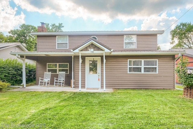 166 Indian Trl, Columbiaville, MI 48421 - traditional home with a chimney, a front lawn, and a patio area