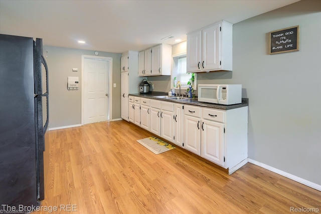 166 Indian Trl, Columbiaville, MI 48421 - kitchen with freestanding refrigerator, white microwave, dark countertops, light wood-type flooring, and recessed lighting