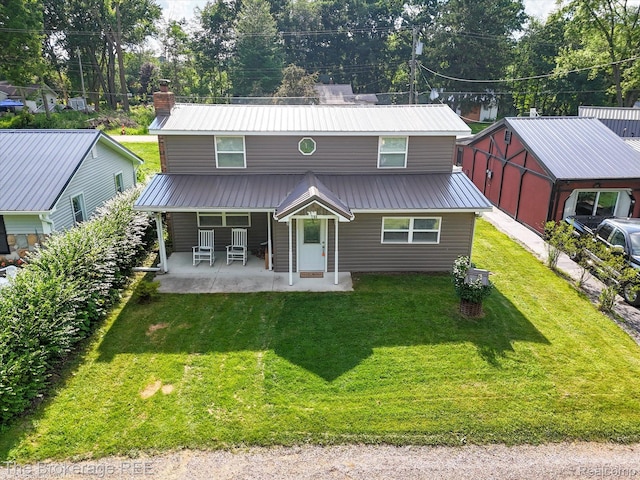 166 Indian Trl, Columbiaville, MI 48421 - view of front facade featuring a metal roof, a front lawn, and a chimney