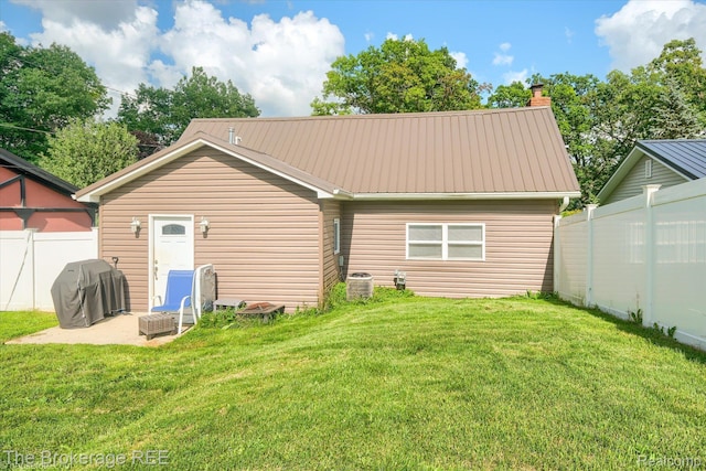 166 Indian Trl, Columbiaville, MI 48421 - rear view of property featuring a metal roof and a chimney