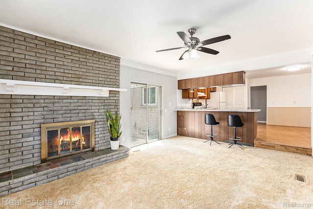 3408 Ardmore Dr, Troy, MI 48083 - living room with light carpet, a ceiling fan, a fireplace, and a wainscoted wall