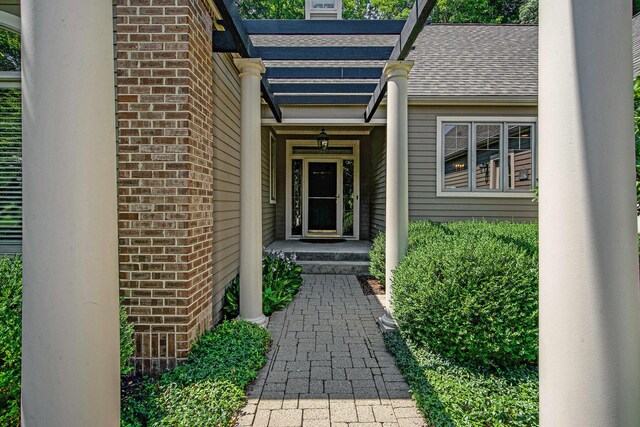 2736 Aspen Ct, Ann Arbor, MI 48108 - property entrance featuring brick siding, a chimney, and roof with shingles