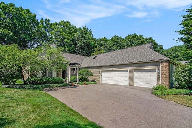 2736 Aspen Ct, Ann Arbor, MI 48108 - view of front of home with asphalt driveway, brick siding, a garage, a front lawn, and roof with shingles