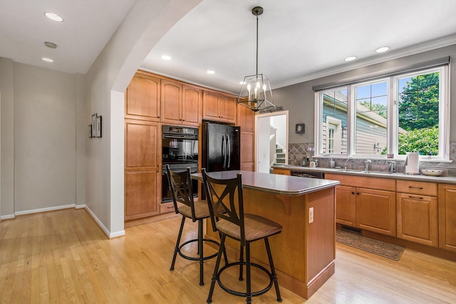 2736 Aspen Ct, Ann Arbor, MI 48108 - kitchen featuring black appliances, backsplash, a breakfast bar area, a center island, and arched walkways