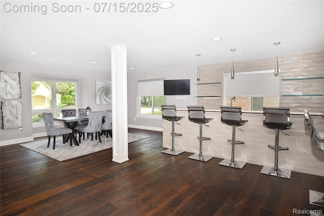 591 Wallace St, Birmingham, MI 48009 - kitchen featuring dark wood finished floors, recessed lighting, a kitchen bar, ornate columns, and pendant lighting