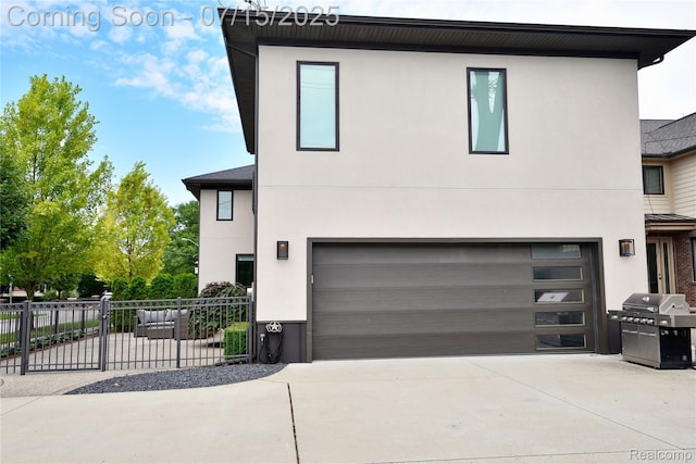 591 Wallace St, Birmingham, MI 48009 - view of front facade featuring driveway, stucco siding, and an attached garage