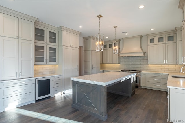 2599 Forest Glen Ct, Rochester, MI 48306 - kitchen with custom range hood, stainless steel stove, beverage cooler, dark wood-style floors, and tasteful backsplash