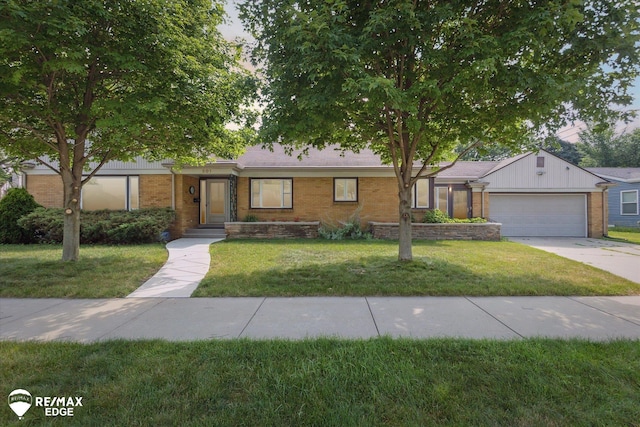 501 Lafayette St, Flint, MI 48503 - ranch-style house with brick siding, a garage, a front yard, and concrete driveway